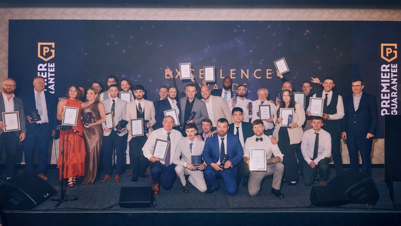 Image of all of the Premier Guarantee 2026 Excellence Awards winners on stage with their awards
