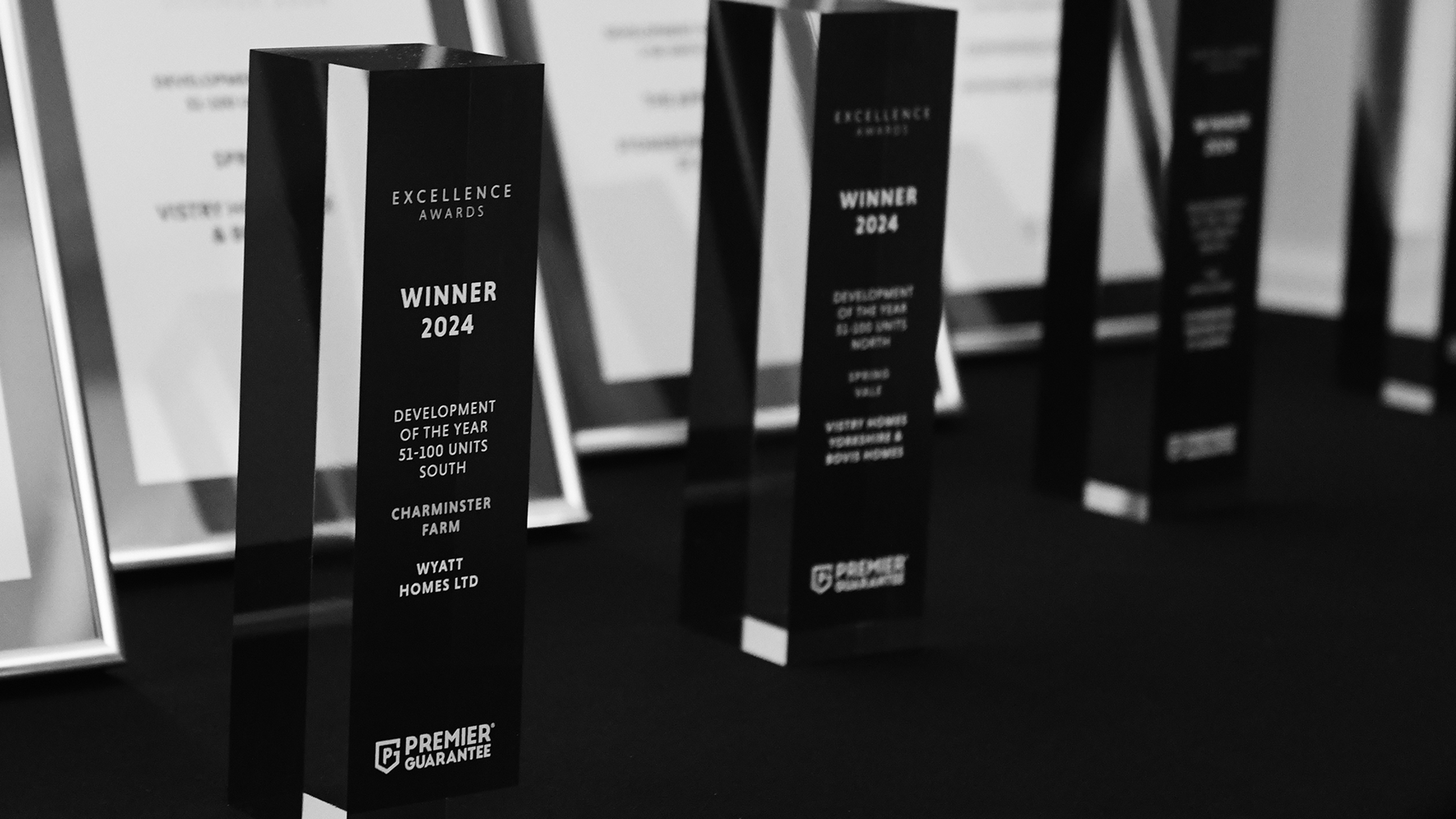 Excellence Awards Excellence Awards trophies lined up - black and white image