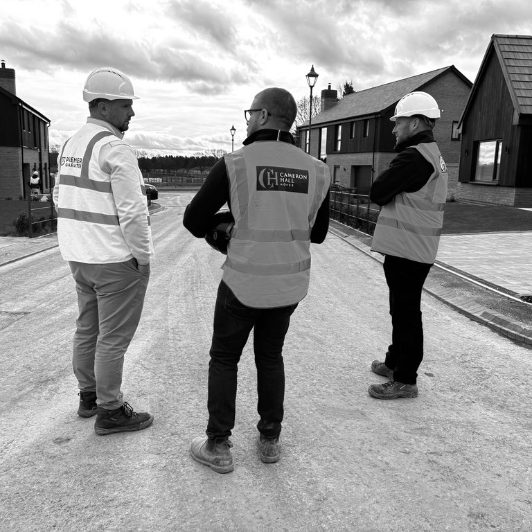 An image of a Cameron Hall Homes site team and Premier Guarantee surveyor