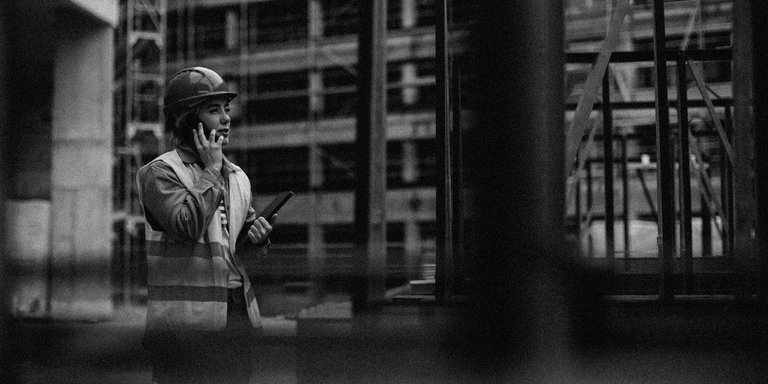 Young female worker having a phone call at a construction site