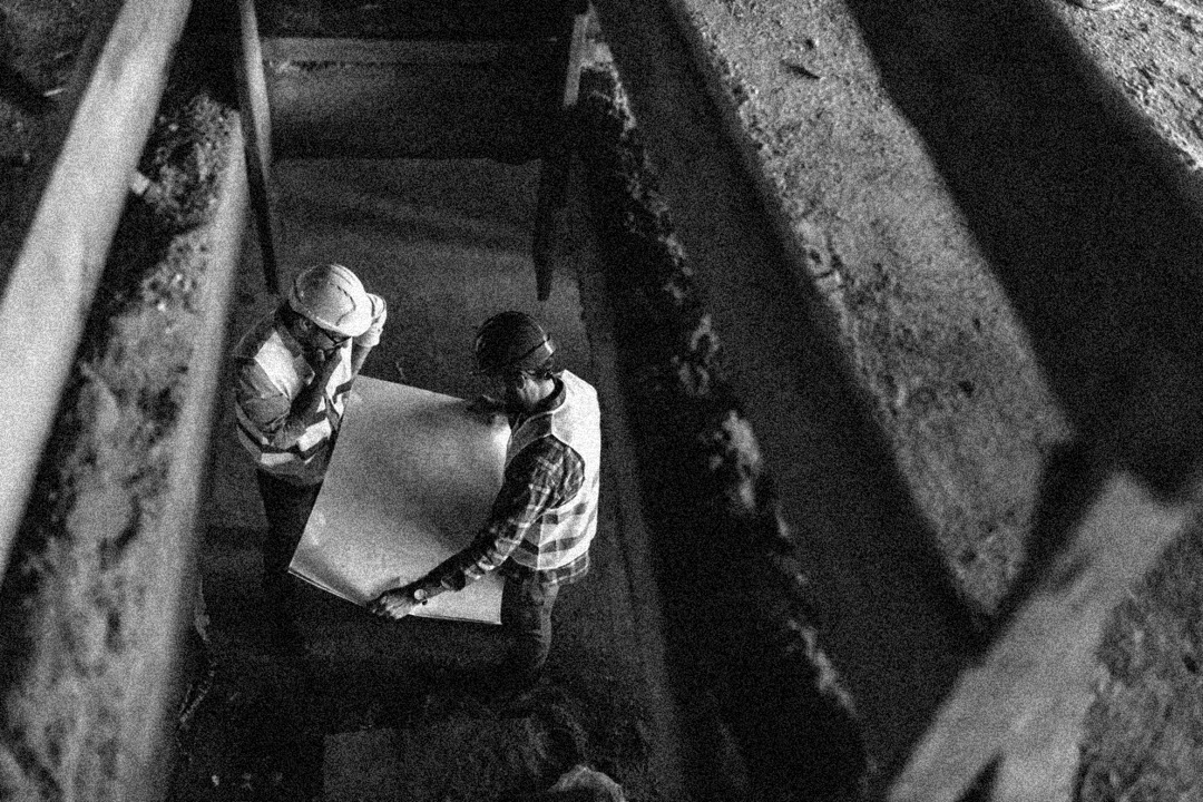 Builders Reading site drawings on construction site - Black and White image
