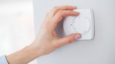 Image of a female hand changing heating in house