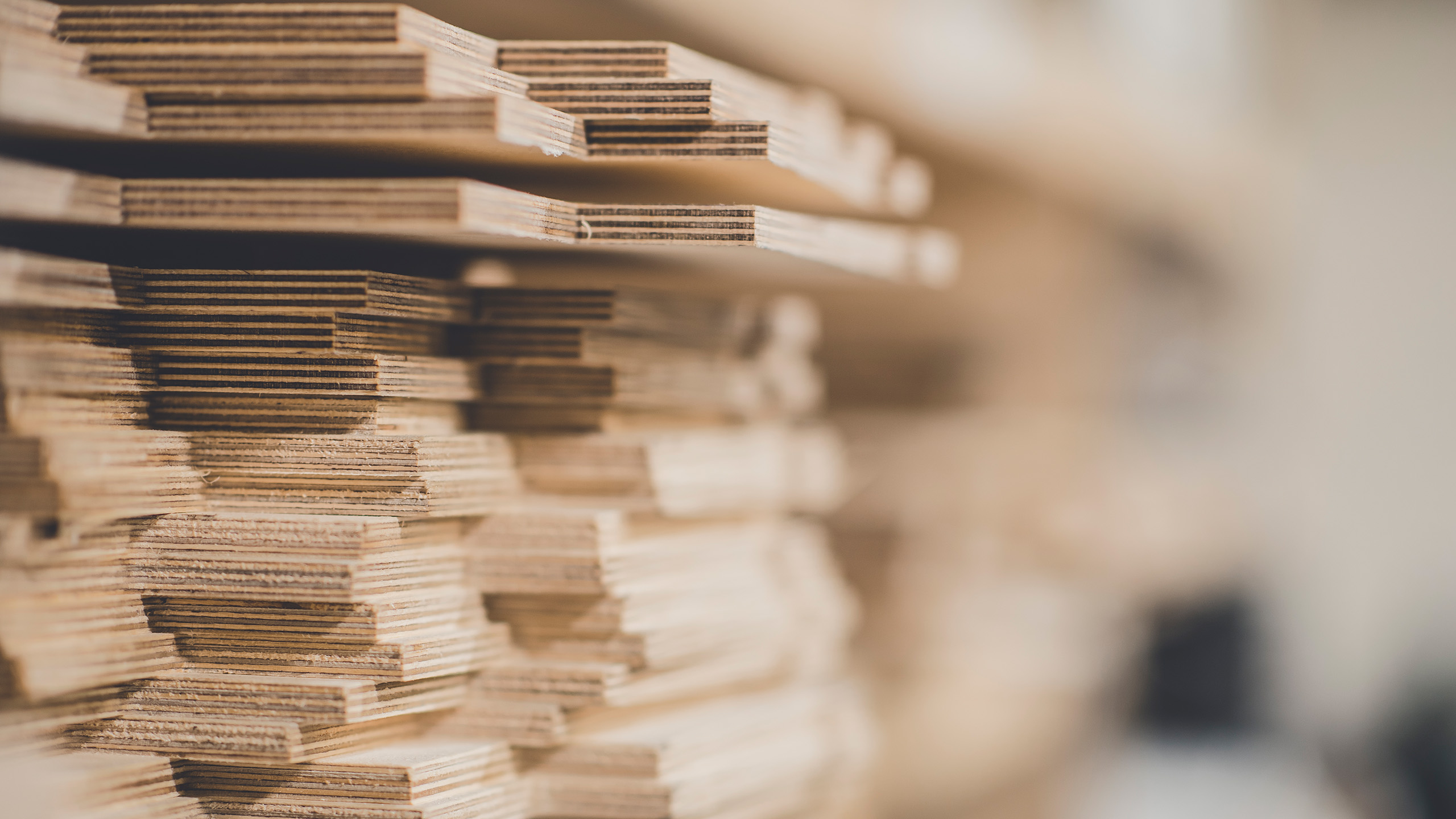 Stacked wooden planks in a workshop Close-up of stacked wooden boards on a shelf, showing layers and texture.