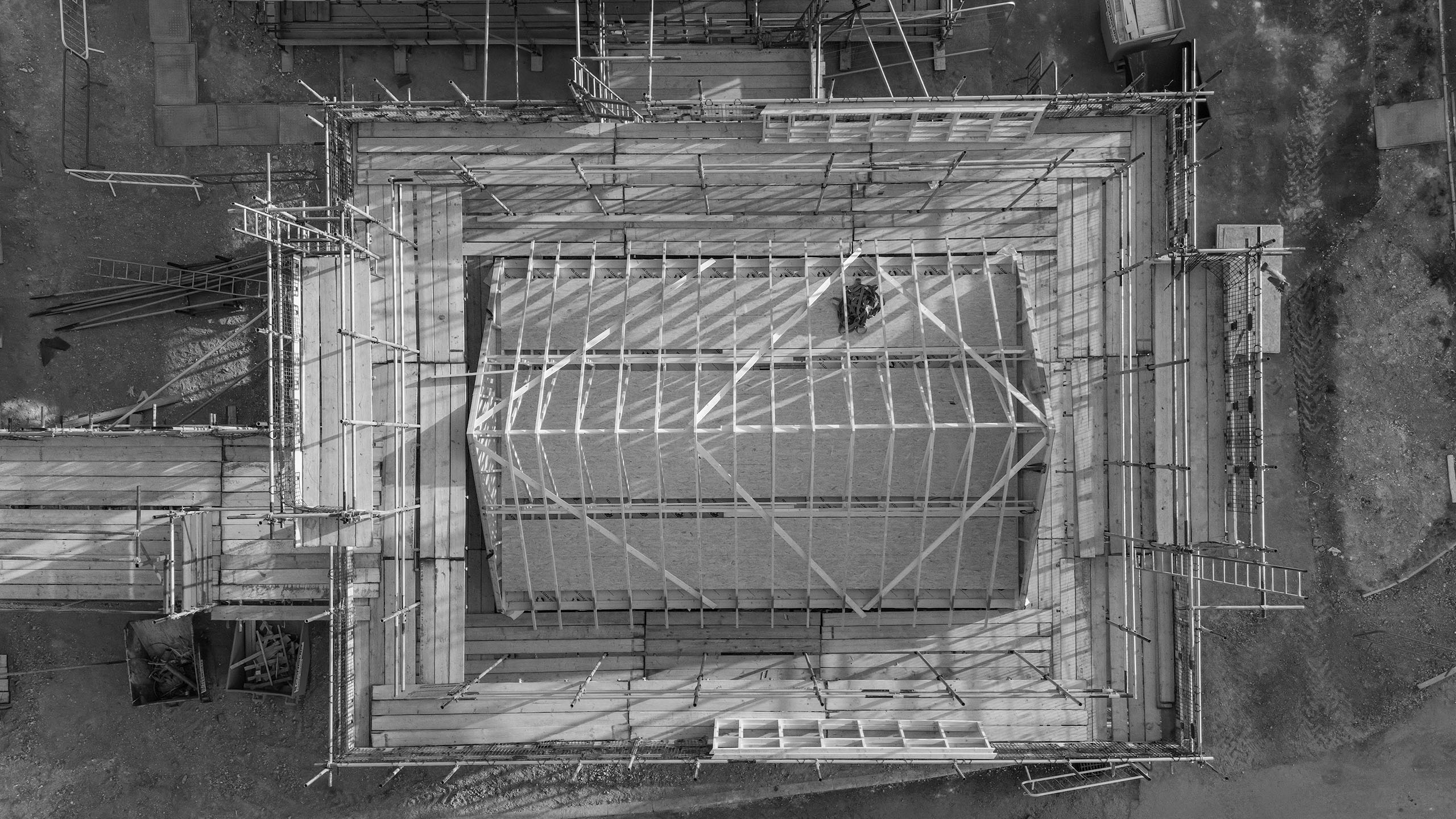 Training Course Questions and Answers Aerial view of a construction site with scaffolding and wooden framework for a building.